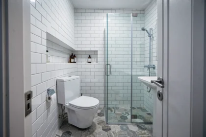 Petite salle d'eau de 2m2 aménagée avec douche d'angle, WC suspendu et lavabo compact