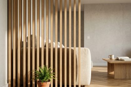 Claustra en bois chêne naturel séparant un coin salon intimiste dans un intérieur scandinave avec parquet en chevrons