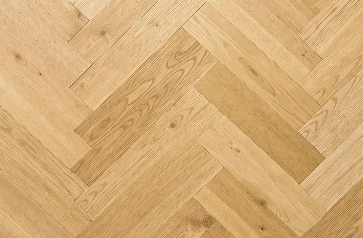 Détail du motif en chevron d'un parquet en chêne massif fraîchement posé