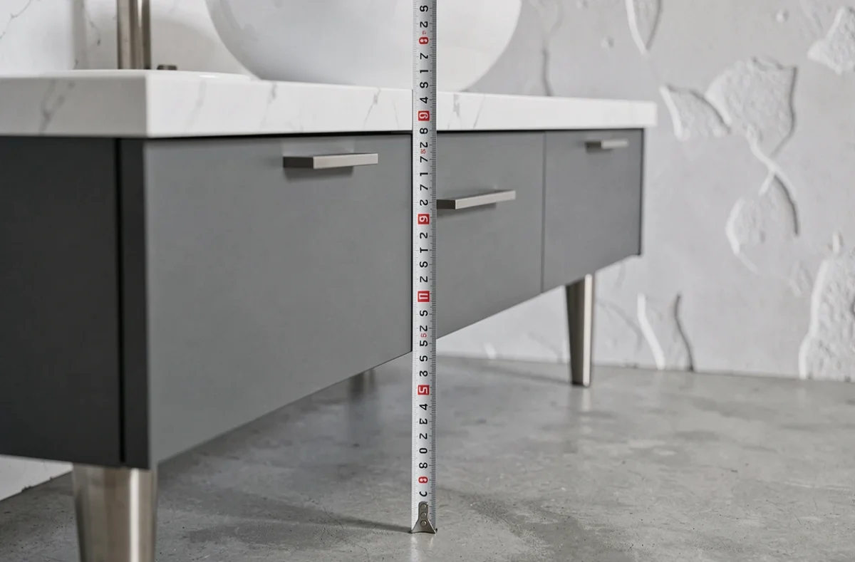 Mètre ruban mesurant la hauteur d'un meuble de salle de bain anthracite à 85 cm du sol, guide visuel pour choisir la hauteur standard d'un meuble vasque